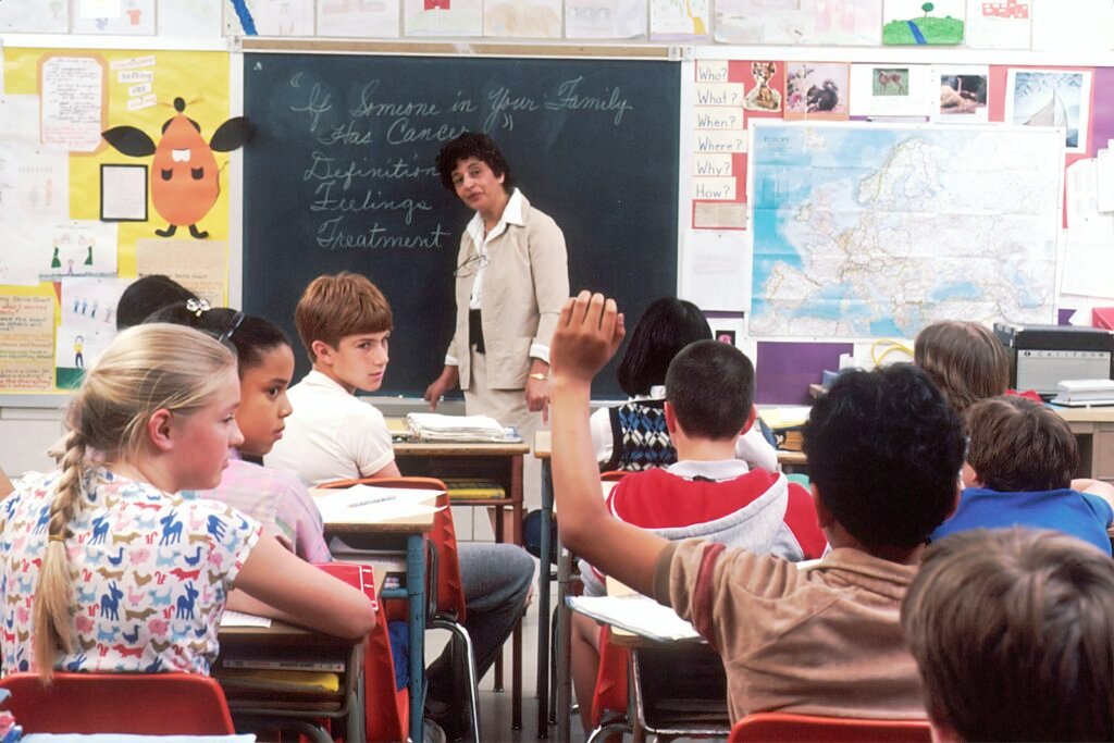 A teacher standing in front of a group of young learners in a classroom
